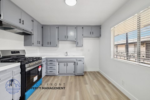 A kitchen with a stove top oven and cabinets.